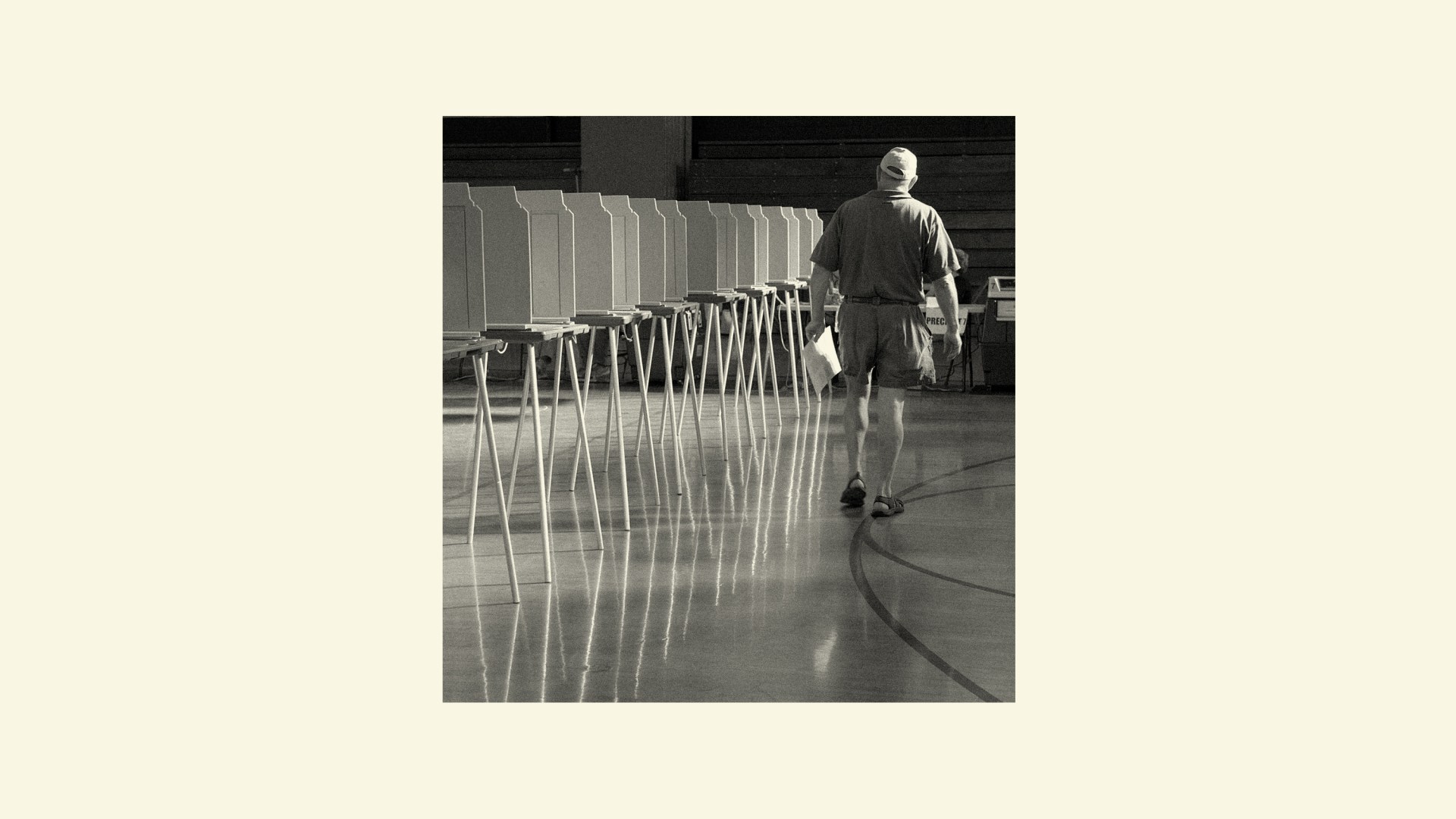 A man walking next to a row of voting booths