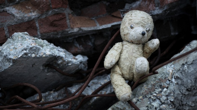 A stuffed animal bear in rubble