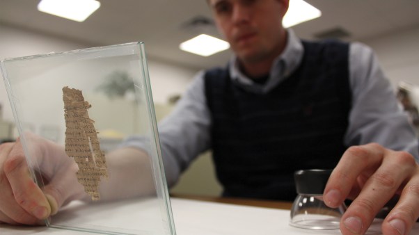 Rory Crowley studies a second-century piece of papyrus.
